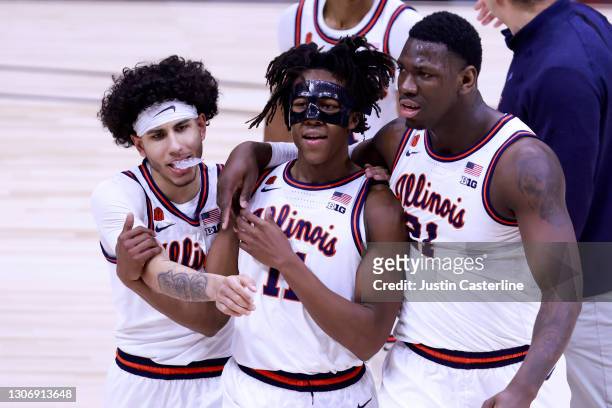 Ayo Dosunmu, Kofi Cockburn and Andre Curbelo of the Illinois Fighting Illini walk off the court after a win over the Iowa Hawkeyes in the Big Ten...
