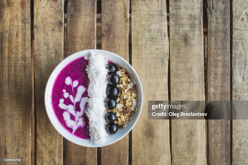 Top view of healthy organic smoothie bowl on wooden table background