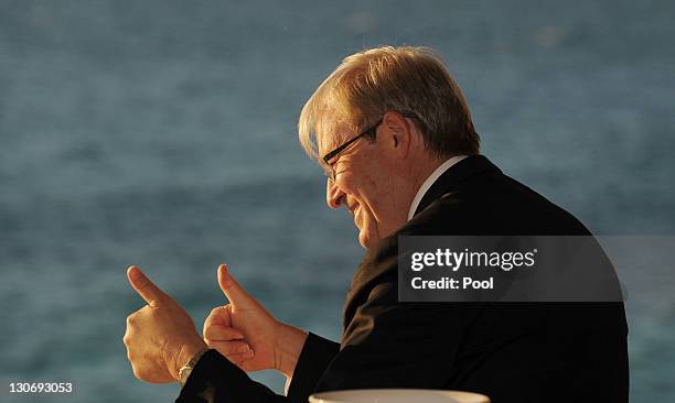 Foreign Minister of Australia Kevin Rudd gives a thumbs up to beach-goers from a balcony at Cottesloe Beach during during a reception for the...