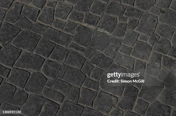 stencilled dark grey concrete patio in a rock flagstone pattern - pavement photos et images de collection