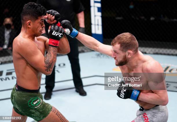 Davey Grant of England punches Jonathan Martinez in a bantamweight fight during the UFC Fight Night event at UFC APEX on March 13, 2021 in Las Vegas,...