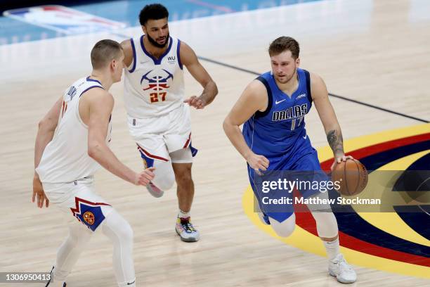 Luka Doncic of the Dallas Mavericks drives against Nikola Jokic and Jamal Murray of the Denver Nuggets in the fourth quarter at Ball Arena on March...