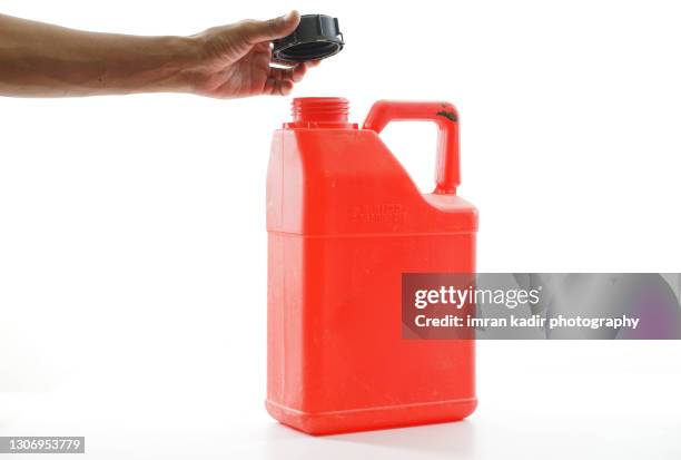 cropped hand holding red gallon container with isolated white background. - récipient sous pression photos et images de collection