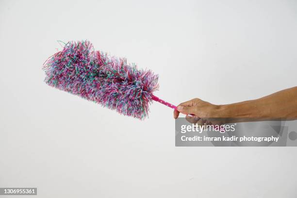 right hand holding feather duster - feather duster stock pictures, royalty-free photos & images