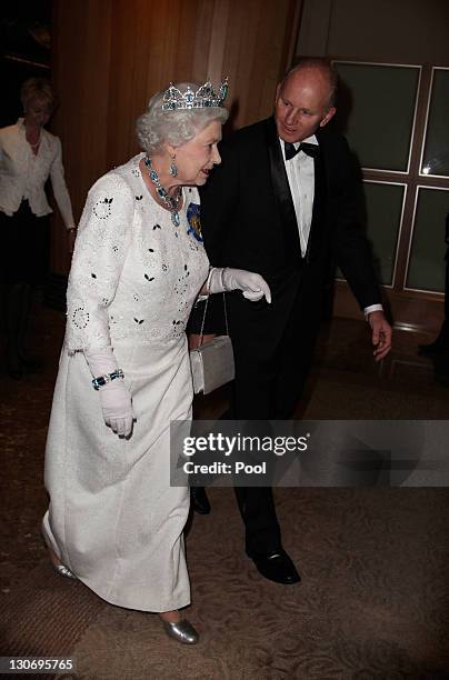 Queen Elizabeth II is escorted by Pan Pacific hotel General Manager Grant Raubenheimer on arriving for a banquet at Pan Pacific Perth Hotel during...