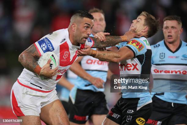 Paul Vaughan of the Dragons puts a fend on Blayke Brailey of the Sharks during the round one NRL match between the St George Illawarra Dragons and...