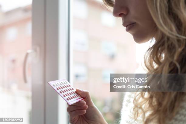 young woman holding contraceptive pills - pill stock-fotos und bilder