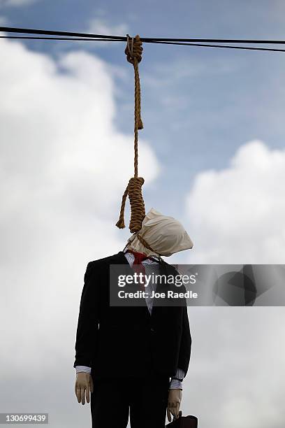 An effigy dressed as a Wall Street banker hangs from a telephone wire on October 28, 2011 in Miami, Florida. An artist known as Above, created the...