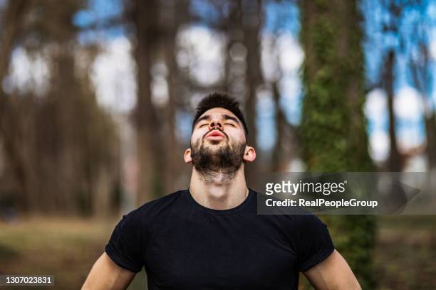 relaxed man  breaths fresh air in a beautiful colorful forest - breathing imagens e fotografias de stock