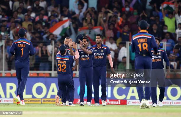 Bhuvneshwar Kumar of India celebrates with team mate Ishan Kishan after taking a catch to dismiss Jason Roy of England during the 2nd T20...