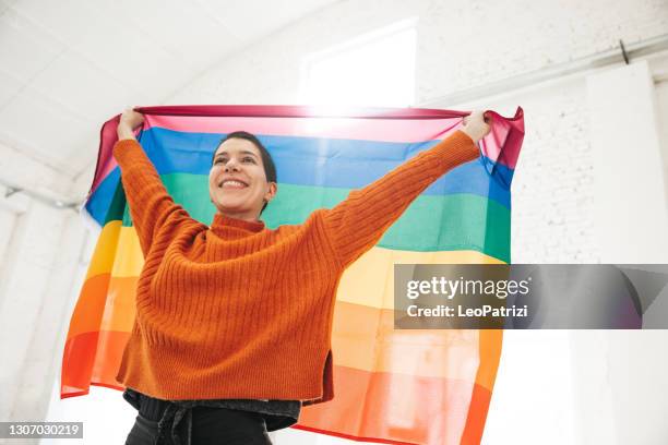 frau steht für lgbtqia-rechte - lgbtqia pride event stock-fotos und bilder