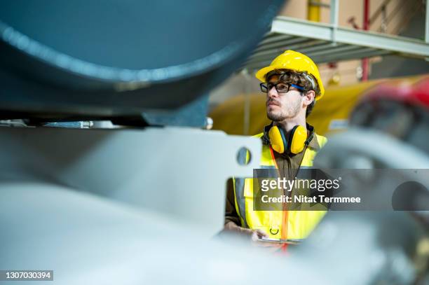 effectively maintain a boiler system. service engineer checking the boiler pressure in control room of food processing plant. - pomp stockfoto's en -beelden
