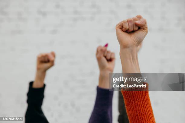 aktivisten protestieren für gleiche frauenrechte - geballte faust stock-fotos und bilder