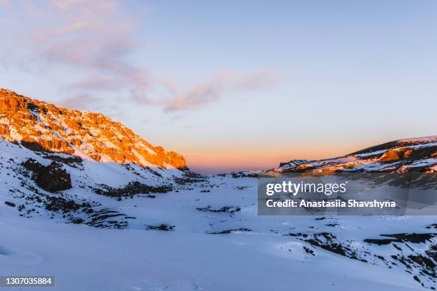 scenic frozen sunrise above the snowcapped mountain peak and glacier on kilimanjaro summit - reaching higher stock pictures, royalty-free photos & images