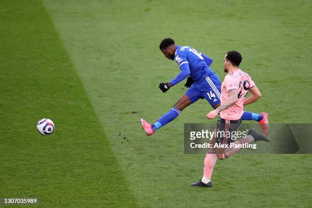 Kelechi Iheanacho of Leicester City scores their side's third goal whilst under pressure from Kean Bryan of Sheffield United during the Premier...
