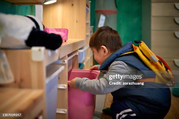 boy pulling and watching at drawer - kids open backpack stock pictures, royalty-free photos & images