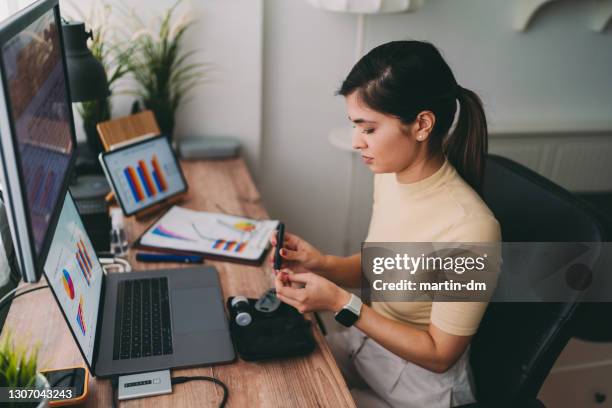 bloedglucosetests met glaucometer en diabetesteststrips - glaucometer stockfoto's en -beelden