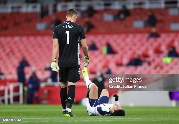 Son Heung-Min of Tottenham Hotspur goes down injured as Bernd Leno of Arsenal looks on during the Premier League match between Arsenal and Tottenham...