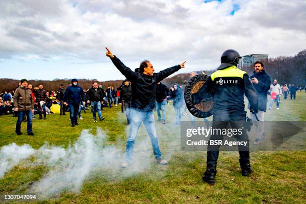Police are seen charging protesters during a protest on the Malieveld against the coronavirus policies and the government on March 14, 2021 in The...