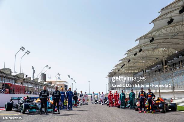 The F1 drivers stand on the grid with their cars during Day One of F1 Testing at Bahrain International Circuit on March 12, 2021 in Bahrain, Bahrain.