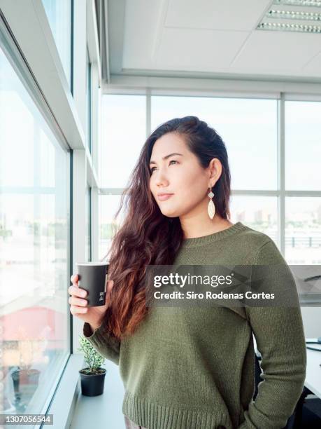 pensive businesswoman with a coffee in the window - encuadre de tres cuartos fotografías e imágenes de stock