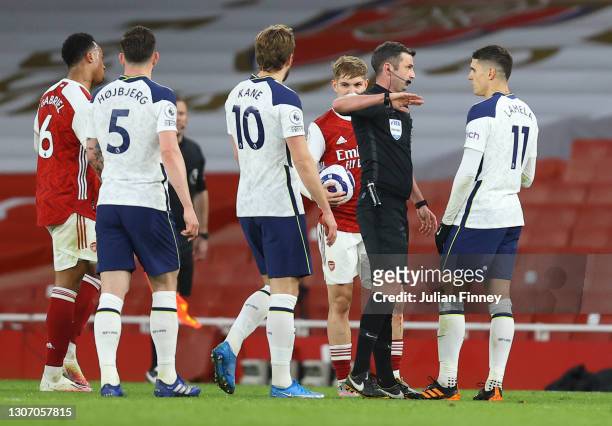 Match Referee, Michael Oliver speaks with Erik Lamela of Tottenham Hotspur after showing him a red card during the Premier League match between...