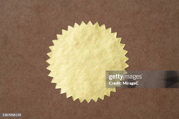 gold starburst shaped seal sticker - labels fotografías e imágenes de stock