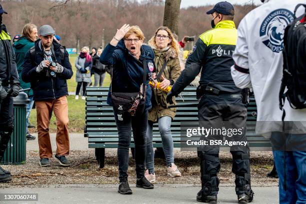 Protester is arguing with a police officer during a protest on the Malieveld against the coronavirus policies and the government on March 14, 2021 in...