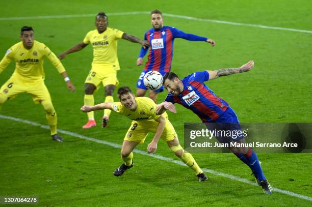 Sergi Enrich of SD Eibar wins a header whilst under pressure from Juan Foyth of Villarreal CF during the La Liga Santander match between SD Eibar and...