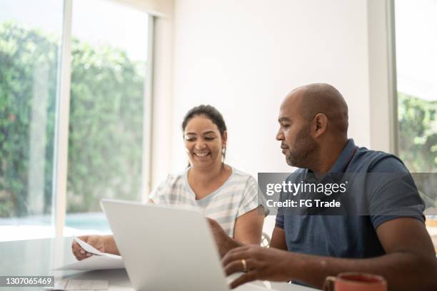 mature couple doing home finances - couple home laptop stock pictures, royalty-free photos & images