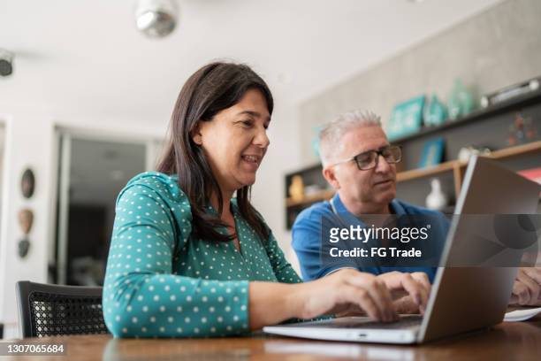 mature couple controling home finances - financial planning at home stock pictures, royalty-free photos & images