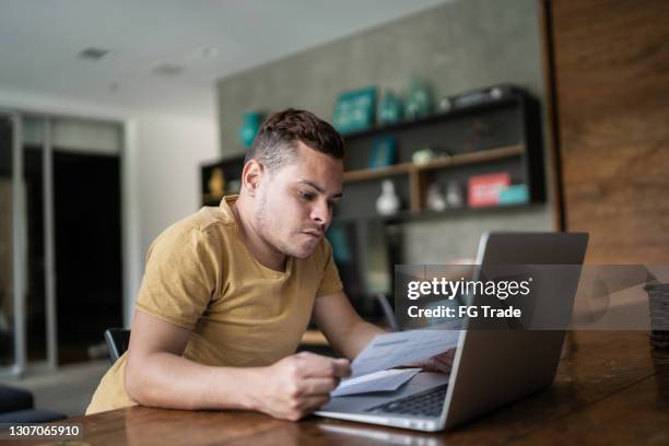 jonge mens met dwerggroei die huisfinanciën doet - dwarf man stockfoto's en -beelden