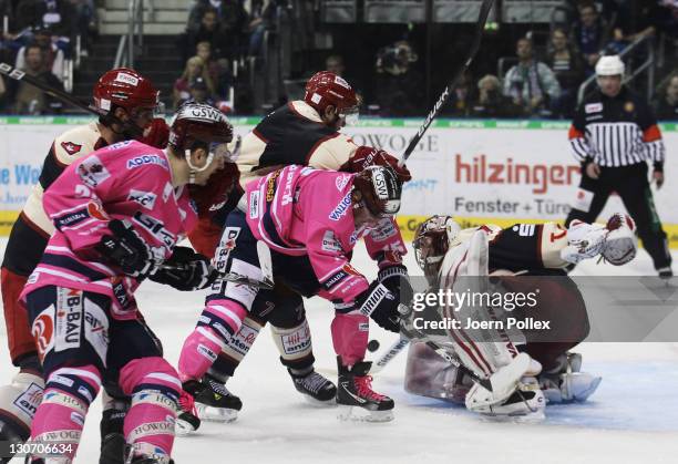 James Travis Mulock of Berlin and Sascha Goc and Dimitri Paetzold of Hannover battle for the puck during the DEL Bundesliga match between EHC...