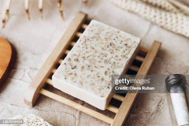 natural soap on a wooden soap dish on a beige background - douche savon photos et images de collection