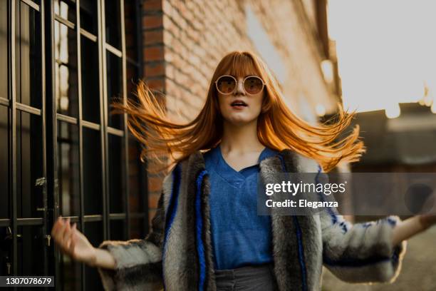 stilvolle junge frau zu fuß auf der straße - eyewear stock-fotos und bilder