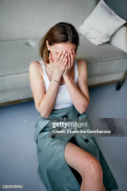 the woman sits on the floor and covers her face with her hands - hand over bildbanksfoton och bilder