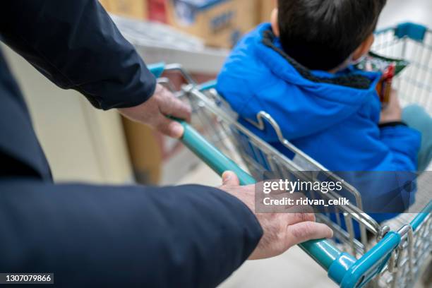 man hand disinfecting shopping cart with alcohol spray for corona virus or covid-19 protection - man washing basket child stock pictures, royalty-free photos & images