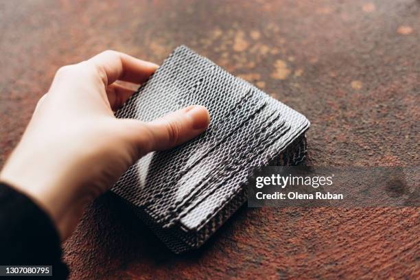 woman's hand holding a deck of cards - barajar fotografías e imágenes de stock