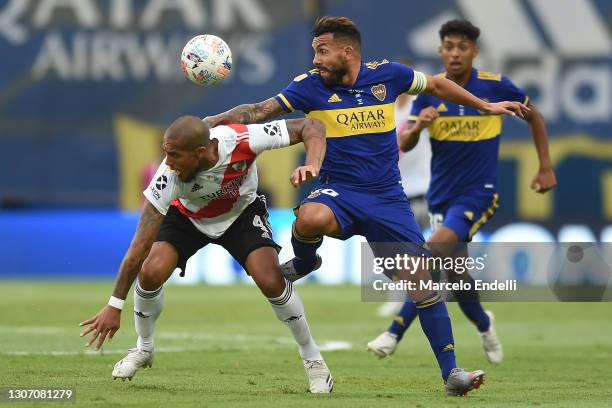 Carlos Tevez of Boca Juniors fights for the ball with Jonathan Maidana of River Plate during a match between Boca Juniors and River Plate as part of...