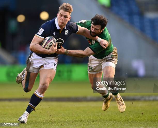 Duhan van der Merwe of Scotland gets past Ireland centre Robbie Henshaw during the Guinness Six Nations match between Scotland and Ireland at...