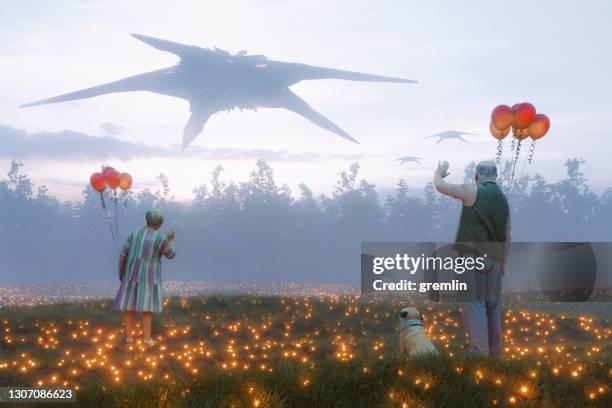 abstract senior couple waving at flying ufos - dumb dog stock pictures, royalty-free photos & images