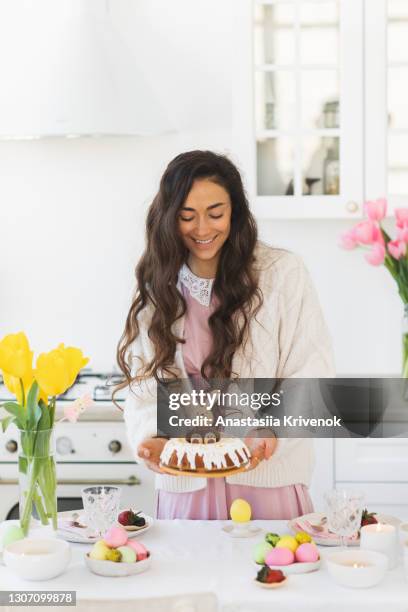 woman served dinner table with delicious homemade easter bundt cake and multicoloured easter eggs. - easter breakfast stock pictures, royalty-free photos & images