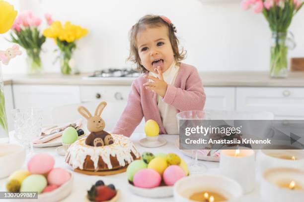 beautiful cute little baby girl celebrating easter at home. - paastafel stockfoto's en -beelden
