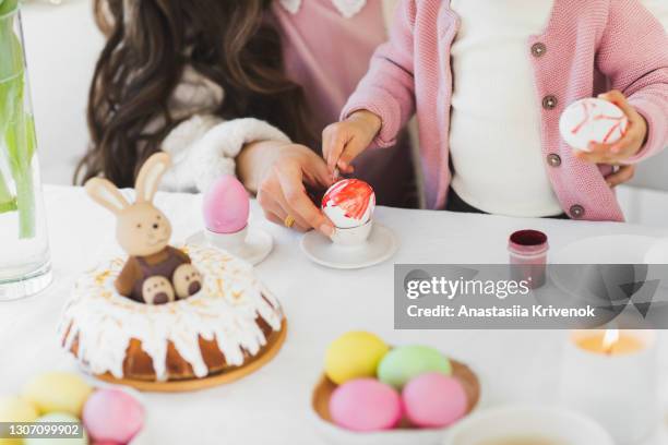 mother's and little girls hands painting easter egg. - baby paint hand stock-fotos und bilder