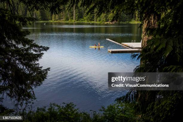 paddleboarding on warm spring day in whistler. - lost lake stock pictures, royalty-free photos & images