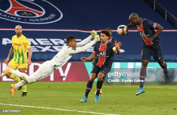 Alban Lafont of FC Nantes stop the ball over Marquinhos and Danilo Pereira of Paris Saint-Germain during the Ligue 1 match between Paris...