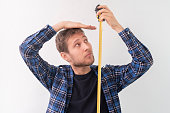 simple adult teenager male person with a roll tape measure the height against the wall
