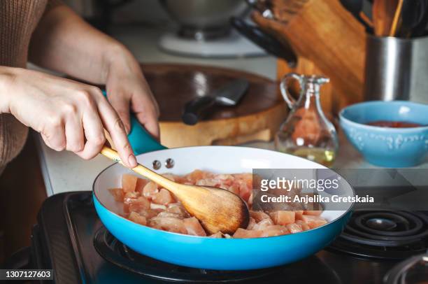 woman frying chicken breast on the skillet. - chicken meat fotografías e imágenes de stock