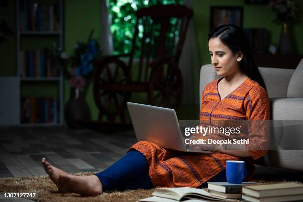 portret van jonge vrouwenzitting op vloer in een ruimte die laptop voor studie gebruikt:- voorraadfoto - op schoot stockfoto's en -beelden