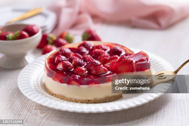 scheibe käsekuchen mit erdbeergelee topping auf spachtel - cremetorte stock-fotos und bilder